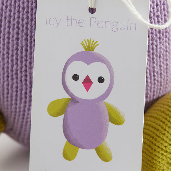 A product tag on a knitted toy reads Icy the Penguin with an illustration of a purple and yellow penguin and the website thejoobles.com below.