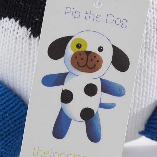 A close-up of a tag showing a cartoon dog named Pip the Dog with blue legs, black spots, and a link to the website thejoobles.com.